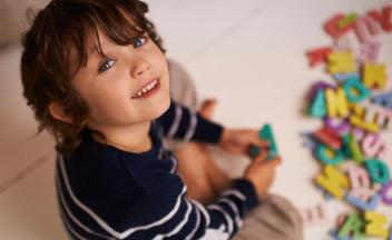 PreK boy playing with magnetic letters