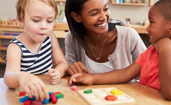 preschool teacher with two kids working on colors and shapes