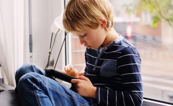 Young boy a home on couch using a phone app