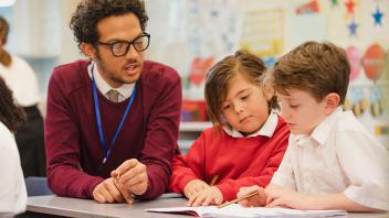 Elementary teacher working on reading fluency with two students