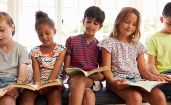 row of elementary kids reading books