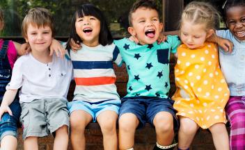 Multicultural group of preschool children sitting in a row