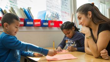 Elementary teacher working with two children at a small table